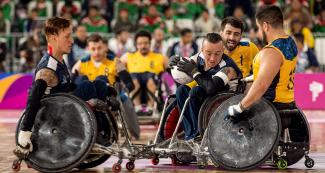 Carlos Neme and Cristian Amaya from Colombia dispute the ball with Gilson Wirzma and Julio Braz in a Lima 2019 wheelchair rugby match at the Villa El Salvador Sports Center