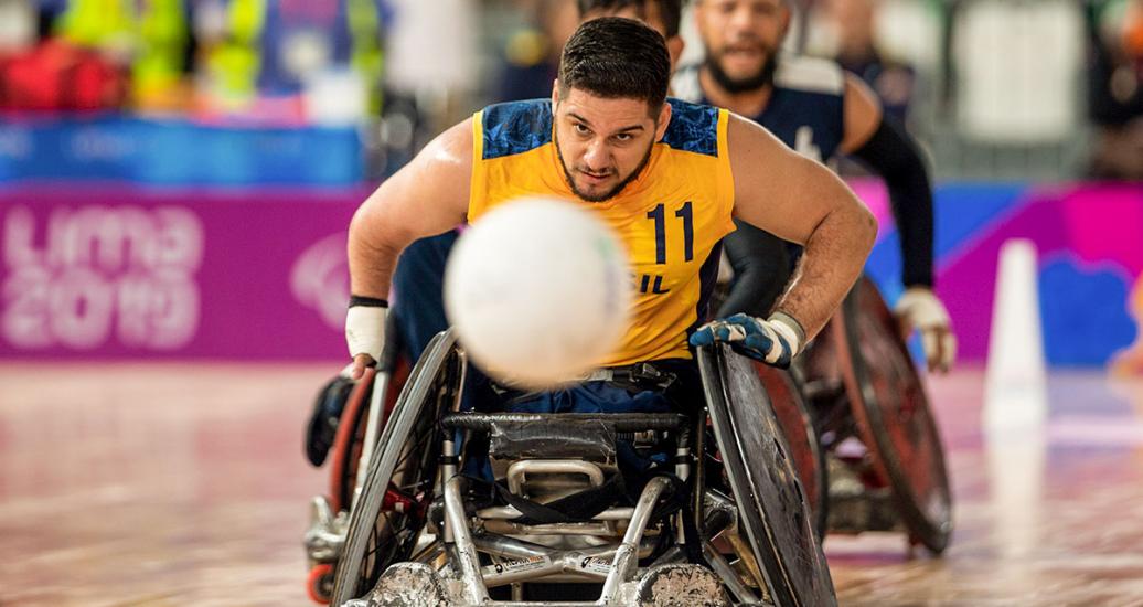 Brazilian Julio Braz tries to take the ball from Colombia during a Lima 2019 wheelchair rugby match at the Villa El Salvador Sports Center