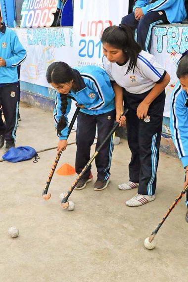 Julieta Mouriño teaches hockey to the students from 7054 Villa María del Triunfo school