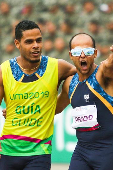 Lucas Prado y su guía Anderson Machado de Brasil celebran la victoria en la final de Para atletismo 100 m masculino T11 en los Juegos Parapanamericanos Lima 2019 en la Villa Deportiva Nacional – VIDENA.
