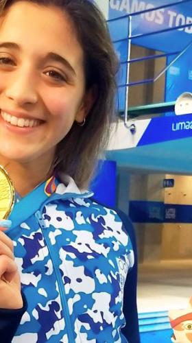 Foto de nadadora argentina levantando medalla de oro en la prueba de los 400 metros libres