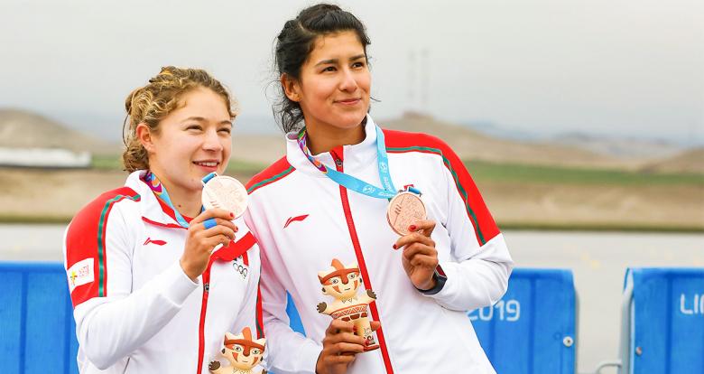 Las mexicanas Karina Alanís y Beatriz Briones enseñan sus medallas de Bronce al público en la Sede Albufera de Medio Mundo, en Lima 2019 