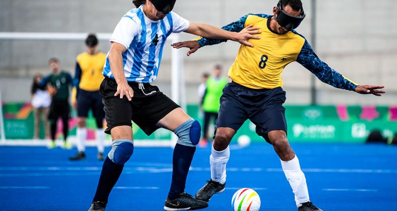 Argentinian Froilan Padila and Brazilian Raimundo de Alves fighting for the ball in Lima 2019 football 5-a-side match at the Villa María del Triunfo Sports Center