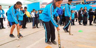 Students from 7054 Villa María del Triunfo school learn how to play hockey