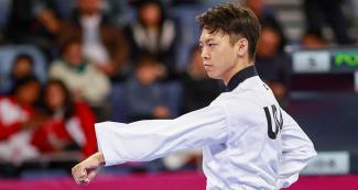 Alex Lee realiza movimiento en competencia de Taekwondo