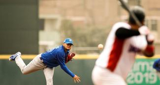 Baseball player Fidencio Flores throws the ball in the match between Nicaragua and Dominican Republic at the venue in Villa María del Triunfo
