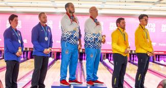 The bowling winners receiving gold at the podium 