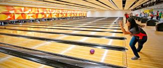 Bowler as she throws the ball down the lane during a bowling championship. 