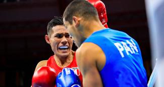 Leodan Pezo contra oponente en competencia de boxeo