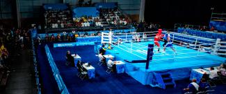 Público de las gradas observa al ring, mientras los luchadores se enfrentan en campeonato de boxeo