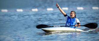 Palista a bordo de su kayak celebrando la victoria en campeonato de canotaje slalom