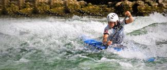 Paddler tries to pass the obstacles in an extreme canoe slalom championship. 