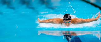 Nadando en estilo mariposa en competencia de natación