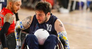  Mariano Santoro (Argentina) holding the ball with his legs in a wheelchair rugby match at Villa El Salvador Sports Center, Lima 2019