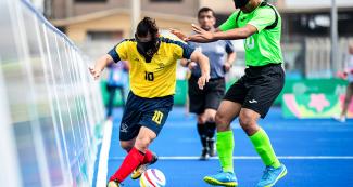 Juan Perez from Colombia fights for the ball vs. Rubiciel de la Cruz from Mexico during football 5-a-side match at the Villa María del Triunfo Sports Center at Lima 2019.