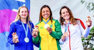 Sofia Reinoso de México (bronce), Evy Leibfarth de EE.UU. (plata) y Ana Satila de Brasil (oro) posan orgullosas con sus medallas de Extreme Slalom K1 femenino en los Juegos Lima 2019 en el Río Cañete en Lunahuana