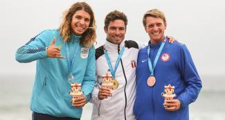 Julian Schweizer de Uruguay (plata), Clemente Benoit de Perú (oro) y Robbins Cole de USA (bronce) celebran orgullosos sus medallas de longboard, en los Juegos Lima 2019 en Punta Rocas