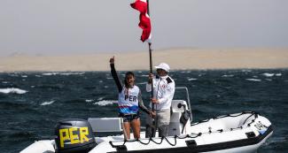 María Bazo of Peru celebrates winning the bronze medal in the Lima 2019 women’s windsurf competition at Paracas Bay
