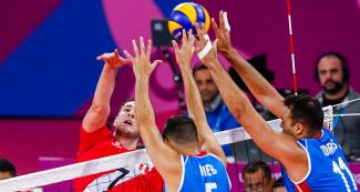 Puerto Ricans Maurice Torres and Pedro Nieves jump to block the ball hit by Peru, in a match held at Callao Regional Sports Village at Lima 2019