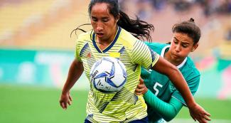 Mayra Ramirez from Colombia and Jimena López from Mexico face off in a football match at the Lima 2019 Games at San Marcos Stadium