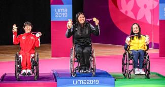 Canadian Yuka Chokyu (silver), Peruvian Pilar Jáuregui (gold) and Brazilian Souza (bronze) proudly posing on the Lima 2019 women’s WH2 Para badminton podium with their medals, at the Villa El Salvador Sports Center.