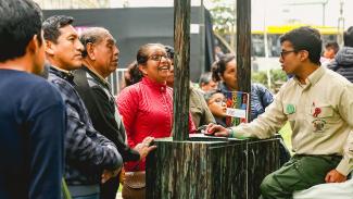 Gesto de las personas que se acercan al módulo de Sernanp para recibir información de voluntario sobre la herramienta de huella de carbono, en Lima 2019