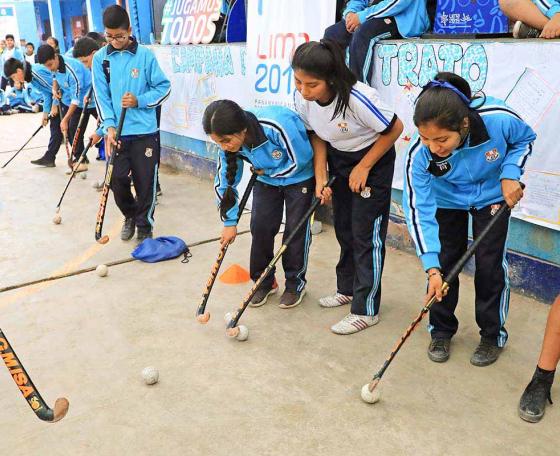 Julieta Mouriño teaches hockey to the students from 7054 Villa María del Triunfo school