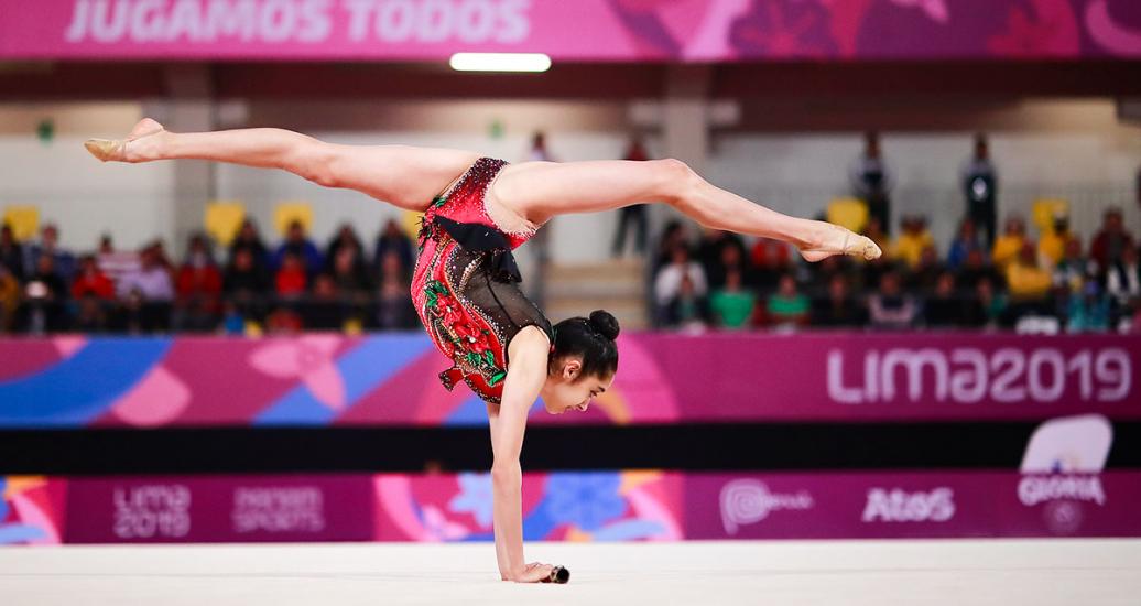 Gymnast Natalie Garcia standing up with her arms and performing an extraordinary pirouette in Lima 2019 Games at the Villa El Salvador Sports Center