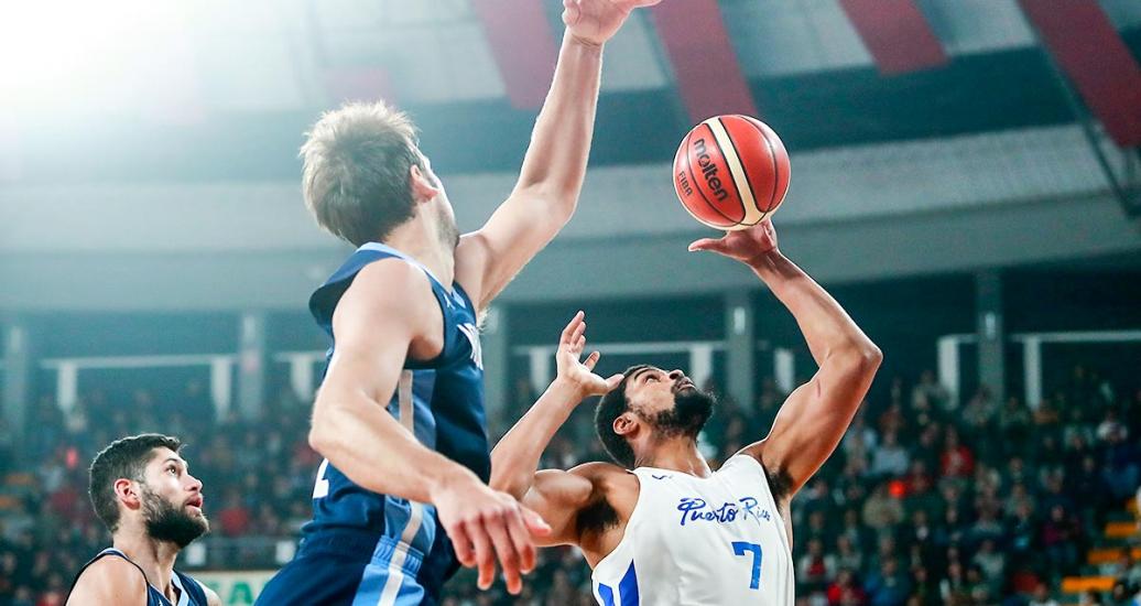 Derek Reese from Puerto Rico and Marcos Delia from Argentina try to catch the ball in the Lima 2019 basketball game at the Eduardo Dibós Coliseum