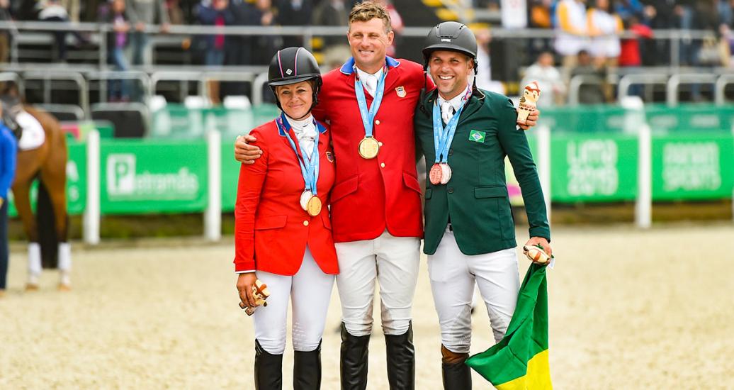 Lynn Symansky and Boyd Martin from USA, who claimed the silver and gold medals, respectively, and Brazilian Carlos Parro, who took the bronze, pose together on the Lima 2019 equestrian podium at the Army Equestrian School