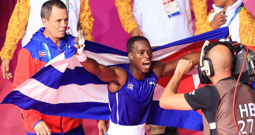 El cubano, David Caballero, celebra su triunfo en la categoría mosca ligera masculina sosteniendo la bandera de su país, en los Juegos Lima 2019, en la Villa Deportiva Regional del Callao