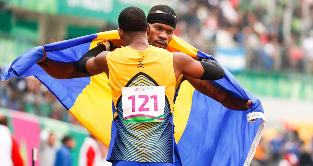 Orial Swift y Shane Brathwaite de Barbados se abrazan tras triunfo en atletismo, en los Juegos Lima 2019, en la Villa Deportiva Nacional – VIDENA. 