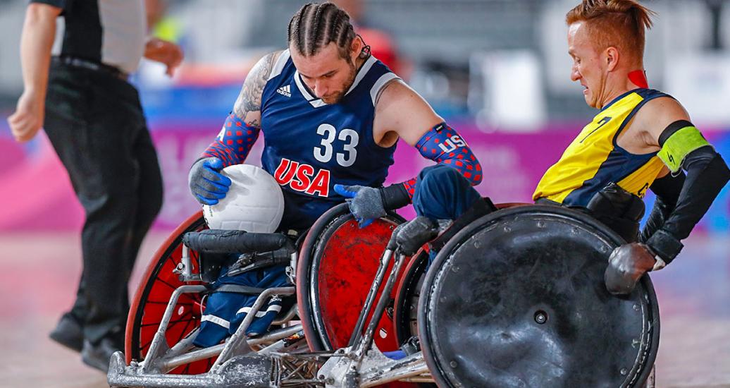 Raymond Hennagir III de EE. UU. compite contra Carlos Neme de Colombia en rugby en silla de ruedas en el Polideportivo Villa El Salvador en Lima 2019