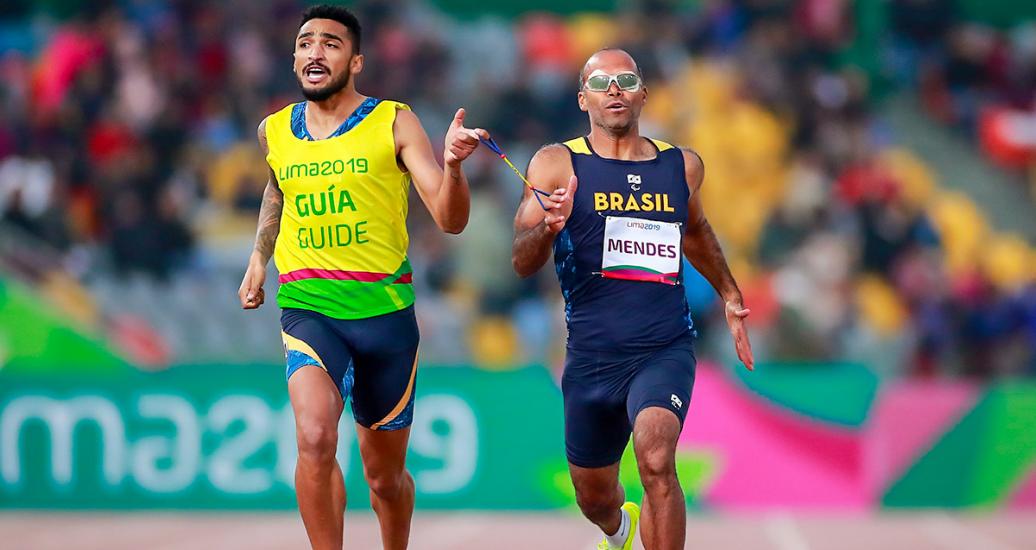 Daniel Mendes de Brasil corre con su guía Wendel Da Souza en la competencia de Para atletismo 400 m hombres T11 en la Villa Deportiva Nacional – VIDENA en Lima 2019