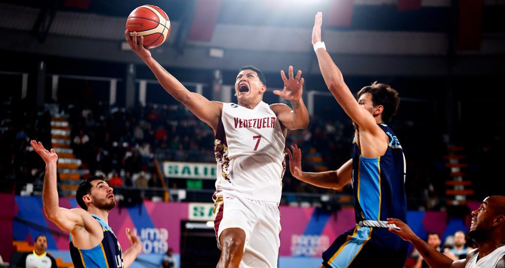 Jordan Zamora de Venezuela salta para encestar frente a uruguayo Santiago Vescovi, en partido de baloncesto, en los Juegos Lima 2019, en el Coliseo Eduardo Dibós.