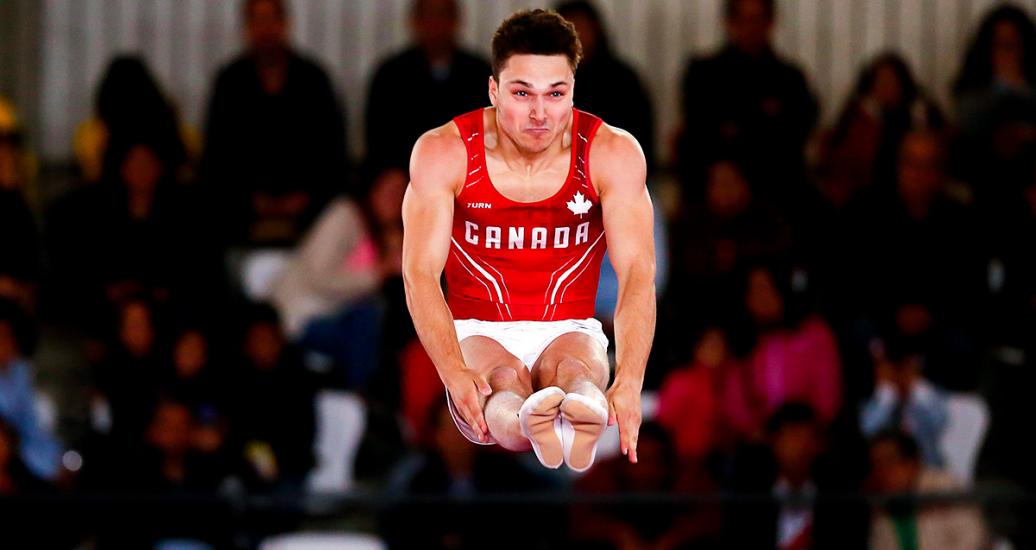 Canada’s Jason Burnett jumps with legs extended in the trampoline competition at the Lima 2019 Games held at the Villa El Salvador Sports Center