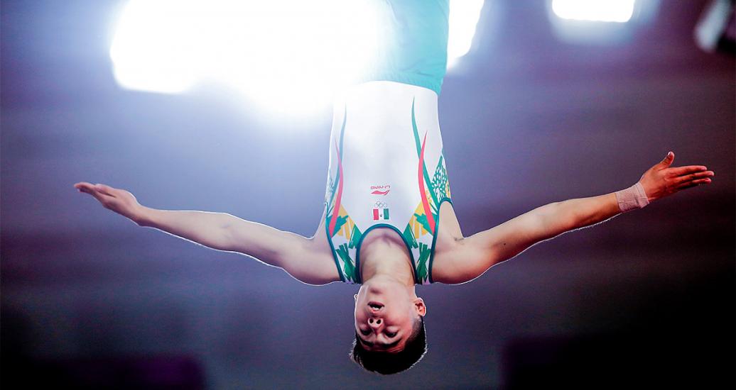 Mexico’s Víctor Rodríguez soars through the air upside down and with arms extended in the trampoline competition of the Lima 2019 Games at the Villa El Salvador Sports Center