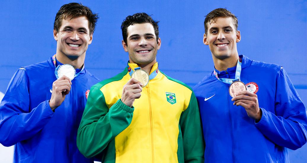Nathan Adrian from the USA (silver), Marcelo Chierghini from Brazil (gold) and Michael Chadwick from the USA (bronze) pose with their Lima 2019 medals in men’s 100 m freestyle at the National Sports Village – VIDENA