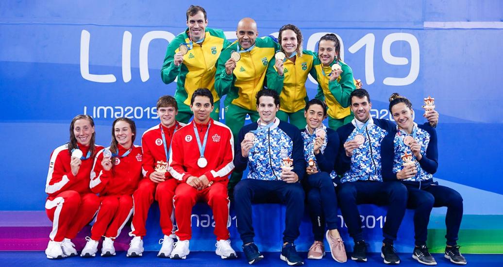 Equipos de natación de Canadá (plata), Argentina (bronce) y Brasil (oro) posan orgullosos con sus medallas de 4x100 relevo combinado mixto en los Juegos Lima 2019 en la Villa Deportiva Nacional – VIDENA. 