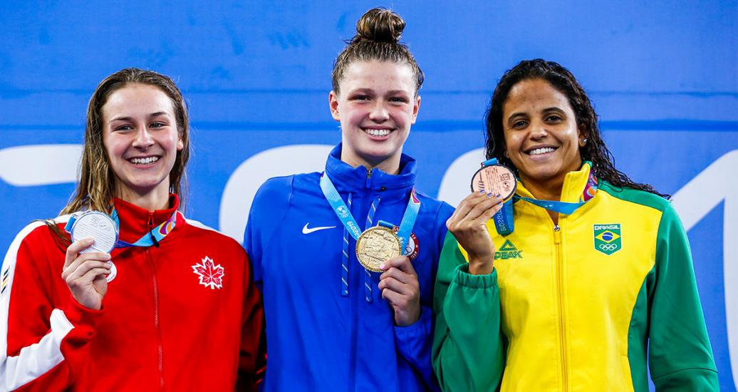 Alexia Zevnik de Canadá (plata), Margo Greer de EEUU (oro) y Larissa Martins de Oliveira de Brasil (bronce) posan orgullosas con sus medallas luego de la competencia de natación 100m estilo libre mujeres de los Juegos Lima 2019 en la Villa Deportiva Nacional – VIDENA.