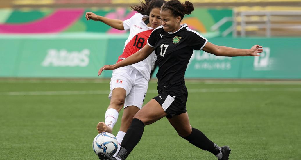 The Peruvian football player Steffanni Otiniano takes the ball from her Jamaican opponent during the football match held at the San Marcos Stadium