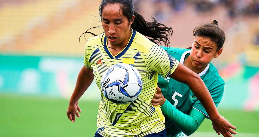 Mayra Ramirez from Colombia and Jimena López from Mexico face off in a football match at the Lima 2019 Games at San Marcos Stadium
